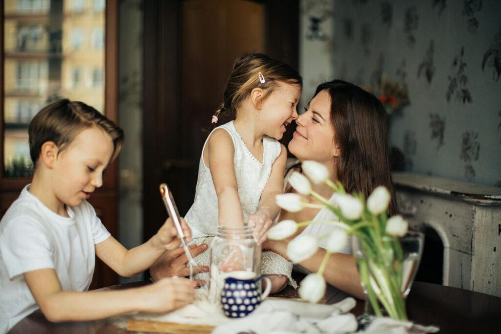 Glückliche Familie, bestehend aus Mutter und zwei Kindern, beim gemeinsamen Kochen und Lachen. Perfekte Momente, um mit VHS digitalisieren Erinnerungen lebendig zu halten.