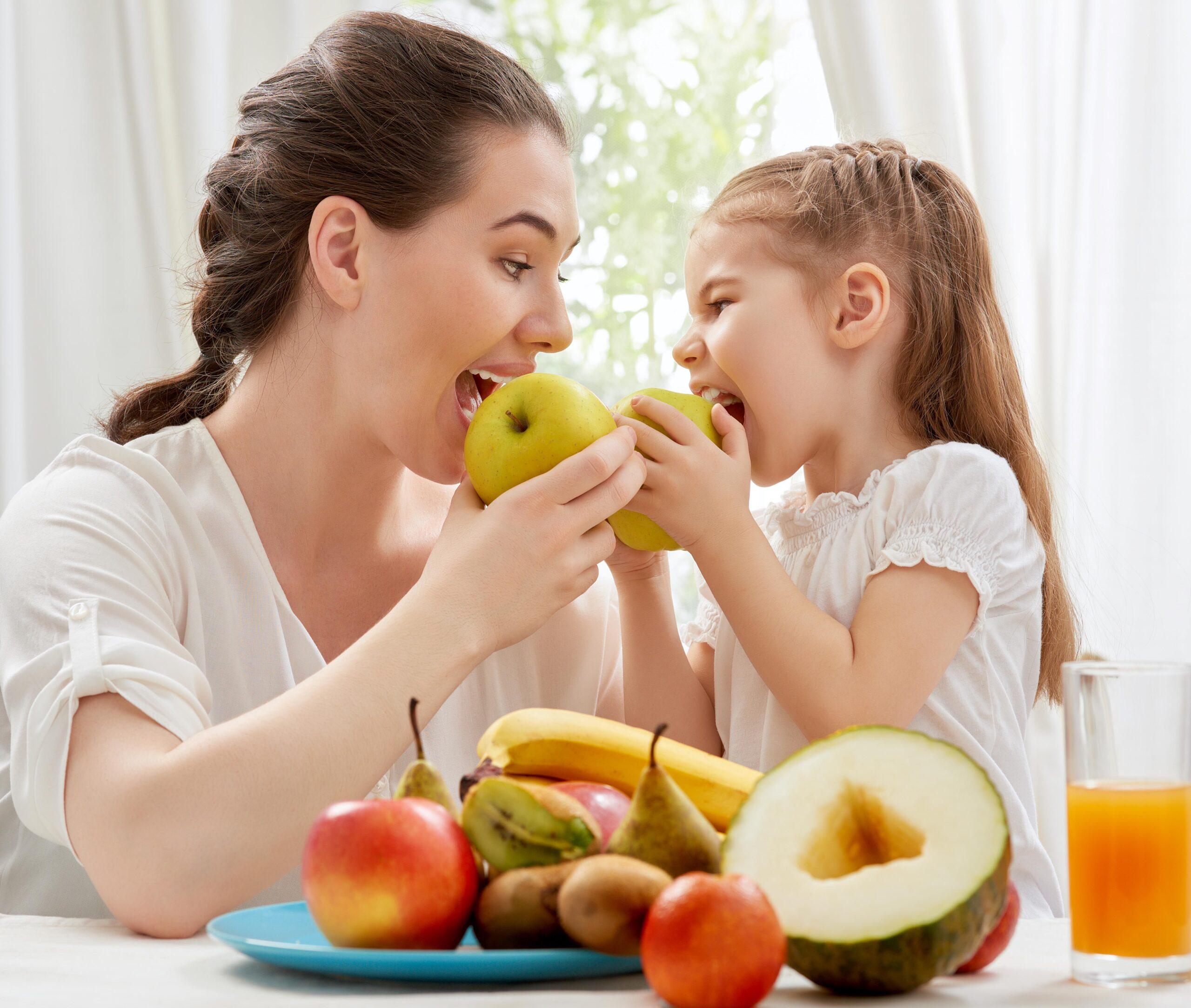 Eine Mutter und ihre Tochter essen Obst