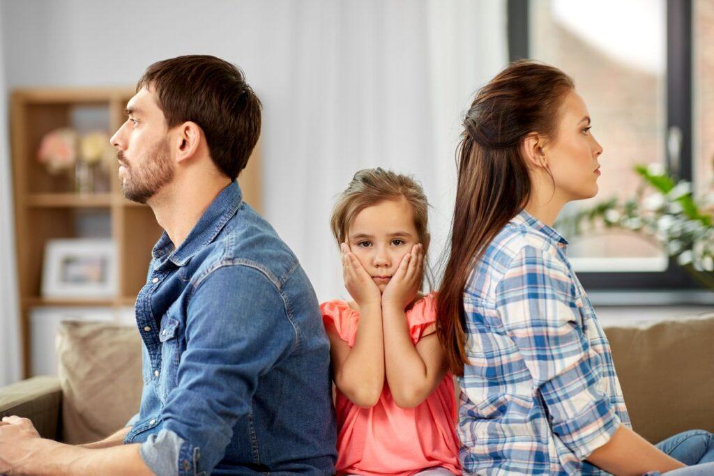 Eltern streiten auf dem Sofa, Kind dazwischen – emotionale Belastung bei Trennung, Thema Rechtsanwalt Familienrecht Bonn