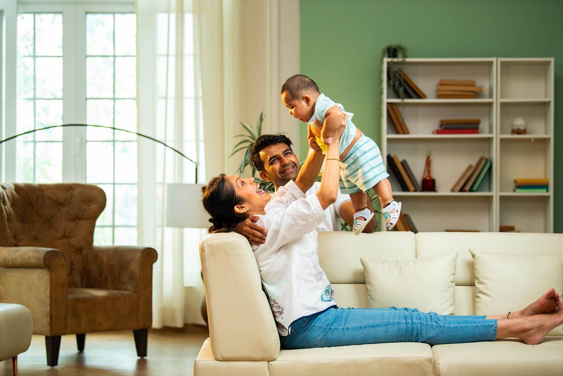 Eltern spielen mit Baby im Wohnzimmer | Moos Wandbild